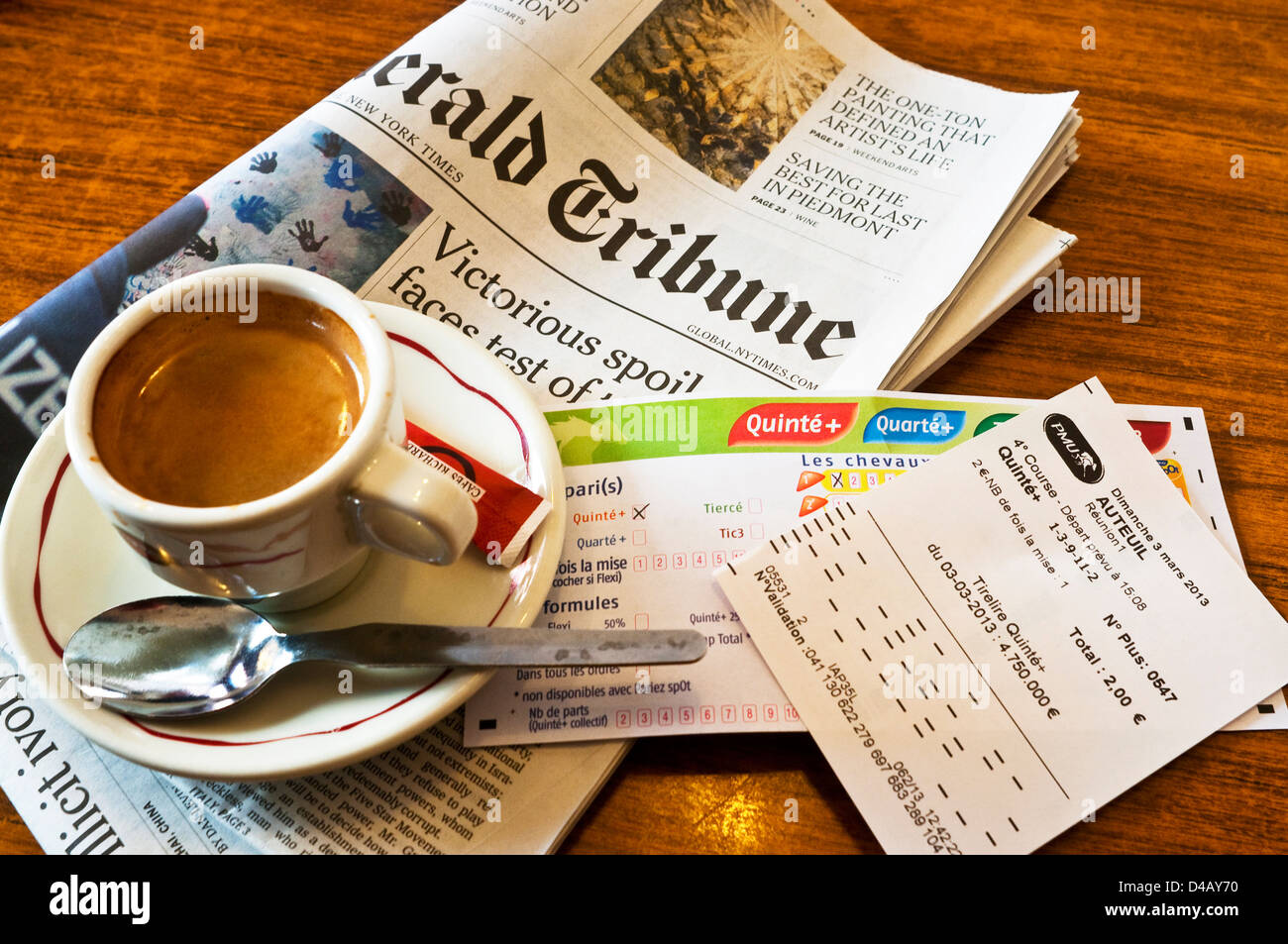 Morgendliche Tasse Kaffee, Wetten rutscht und International Herald Tribune Zeitung - Frankreich. Stockfoto
