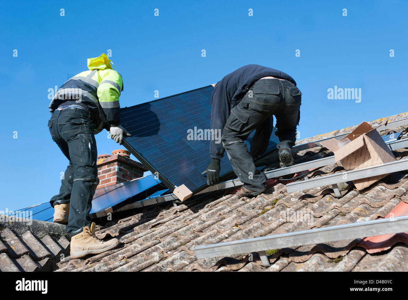 Arbeiter, die Installation von solar-pv-Panels auf Hausdach Stockfoto