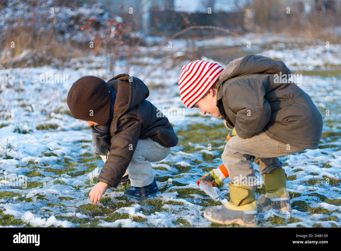 Zwei Jungs (4-7) spielen im Schnee. Stockfoto