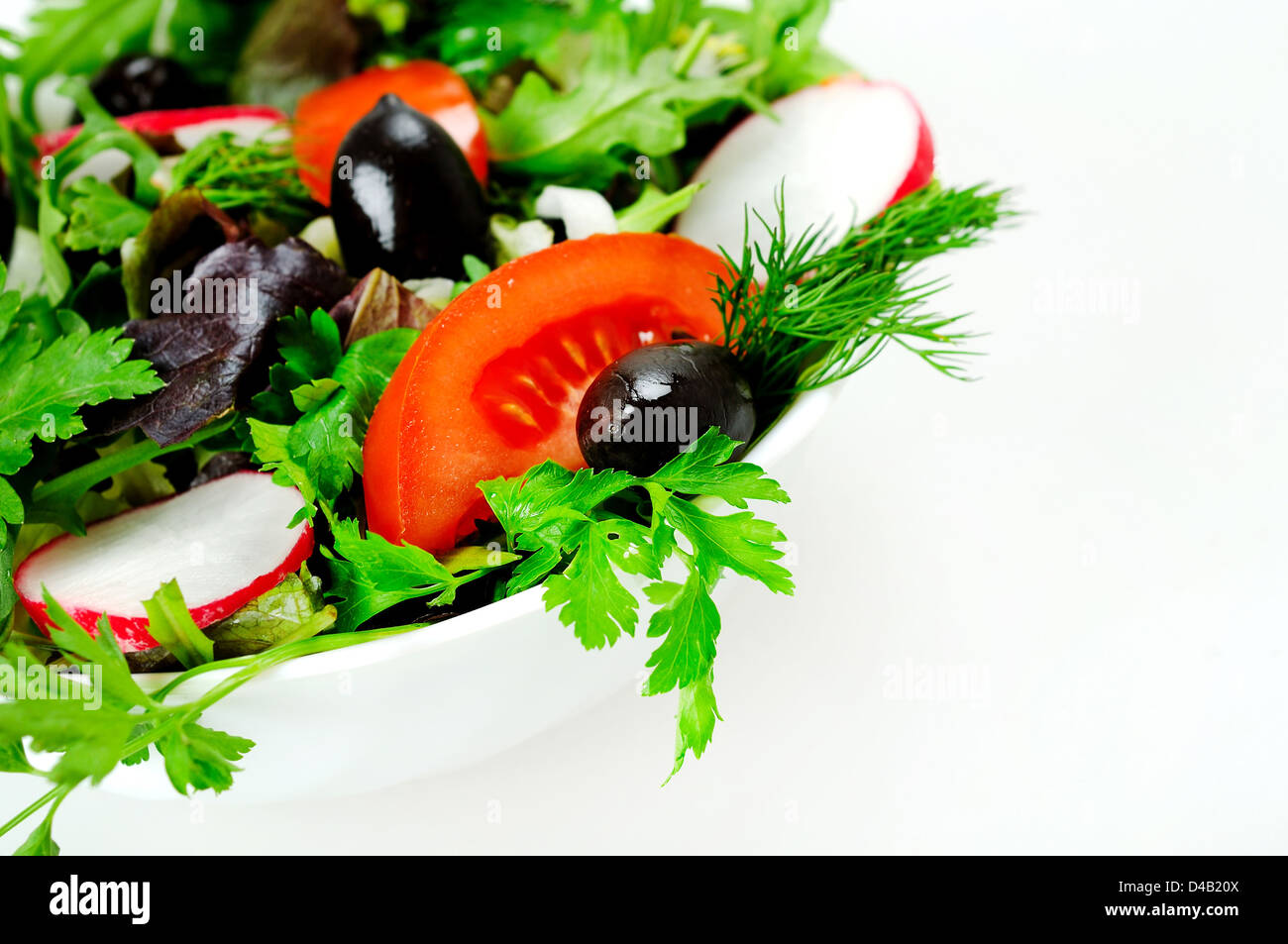 Schüssel mit Salat auf weiß Stockfoto