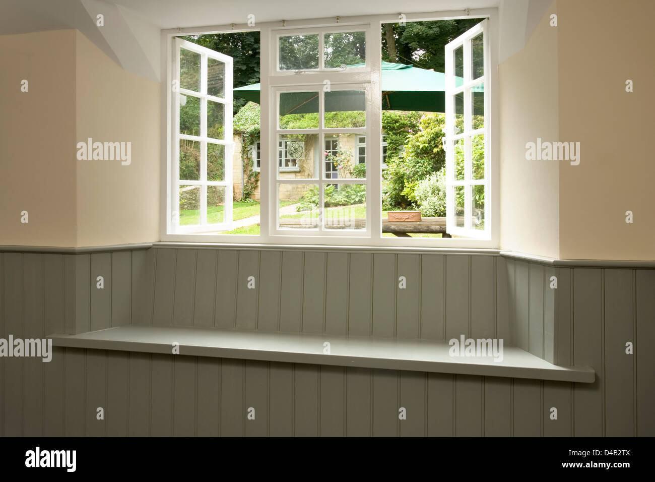 Eine neue lackiertem Holz getäfelten Fensterplatz mit Blick auf den Garten. Stockfoto