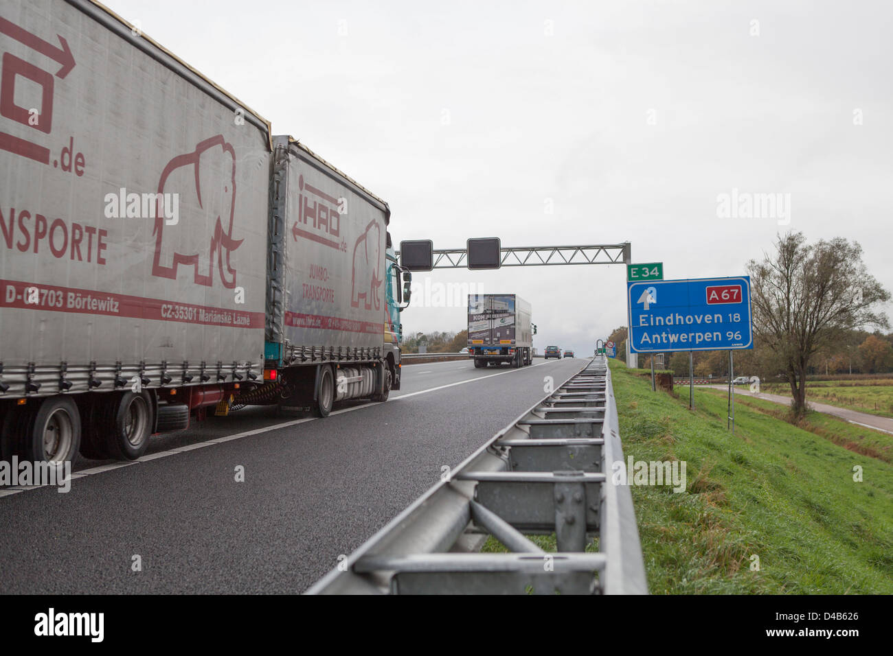 Niederländische Autobahn mit LKW an der A67 Eindhoven vorbei. Die A67 gehört zu der Hauptroute aus Rotterdam und Antwerpen nach Deutschland Stockfoto