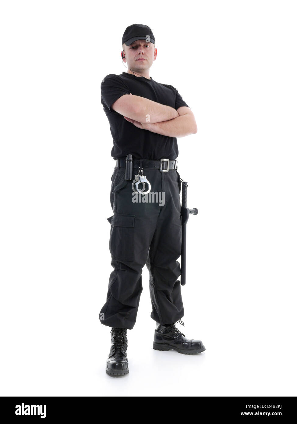 Security-Mann in schwarzer uniform geschossen mit Polizei-Club und selbstbewusst steht mit verschränkten Armen und Handschellen ausgestattet, auf weiß Stockfoto