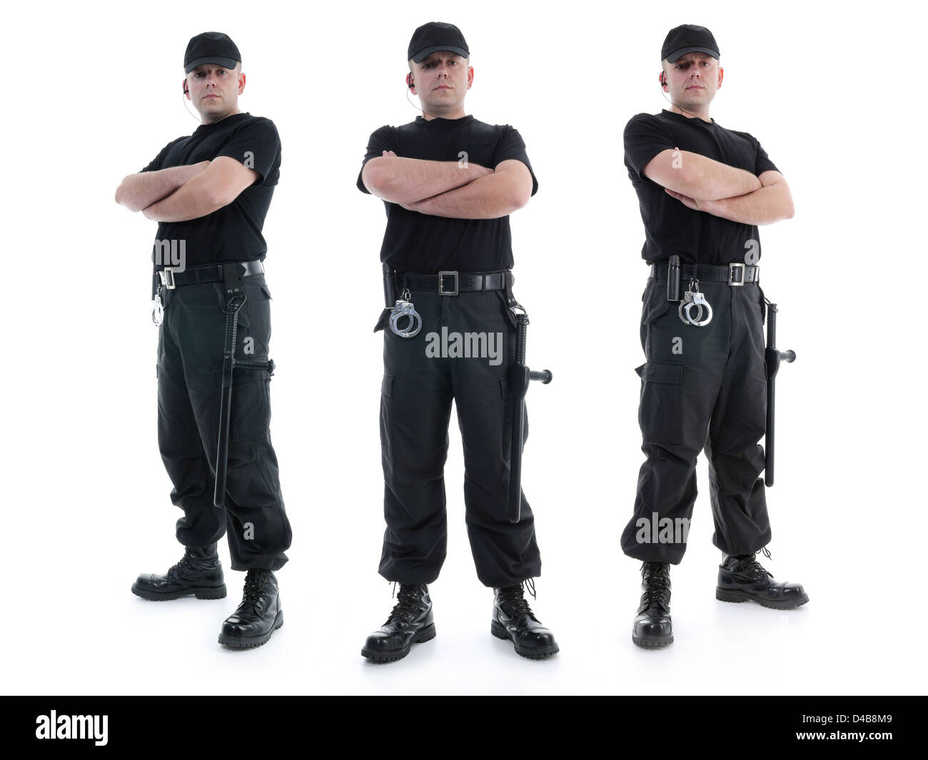 Drei Security-Männer tragen schwarze Uniform mit Polizei-Clubs und Handschellen stehen selbstbewusst mit verschränkten Armen ausgestattet Stockfoto
