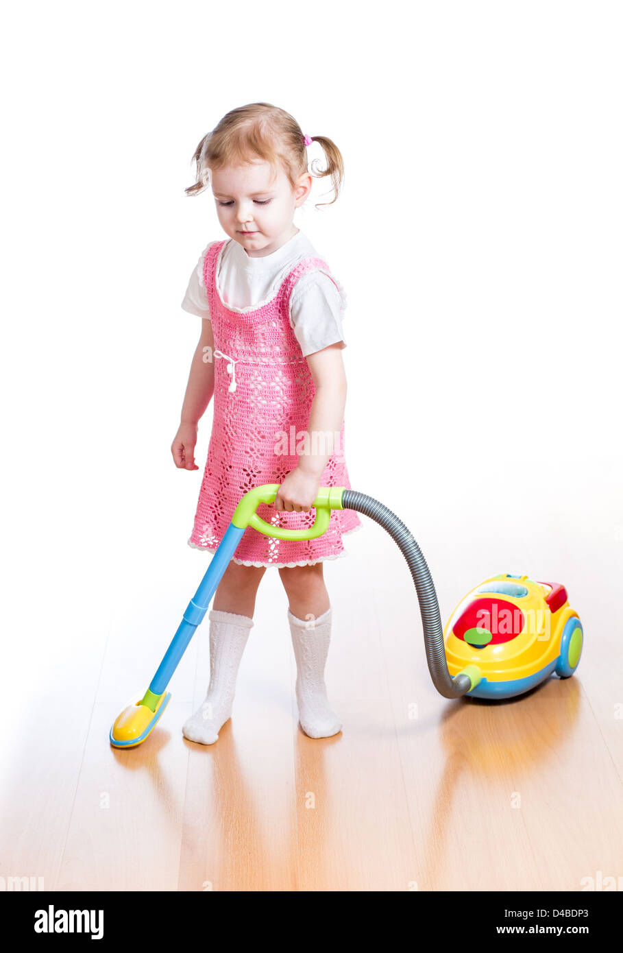 Kind Mädchen spielen und Reinigungsraum mit Spielzeug-Staubsauger Stockfoto