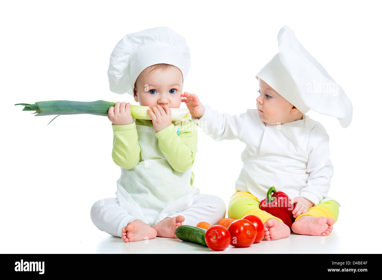 Babys Jungen und Mädchen einen Koch Hut mit gesunden Lebensmitteln Gemüse Stockfoto