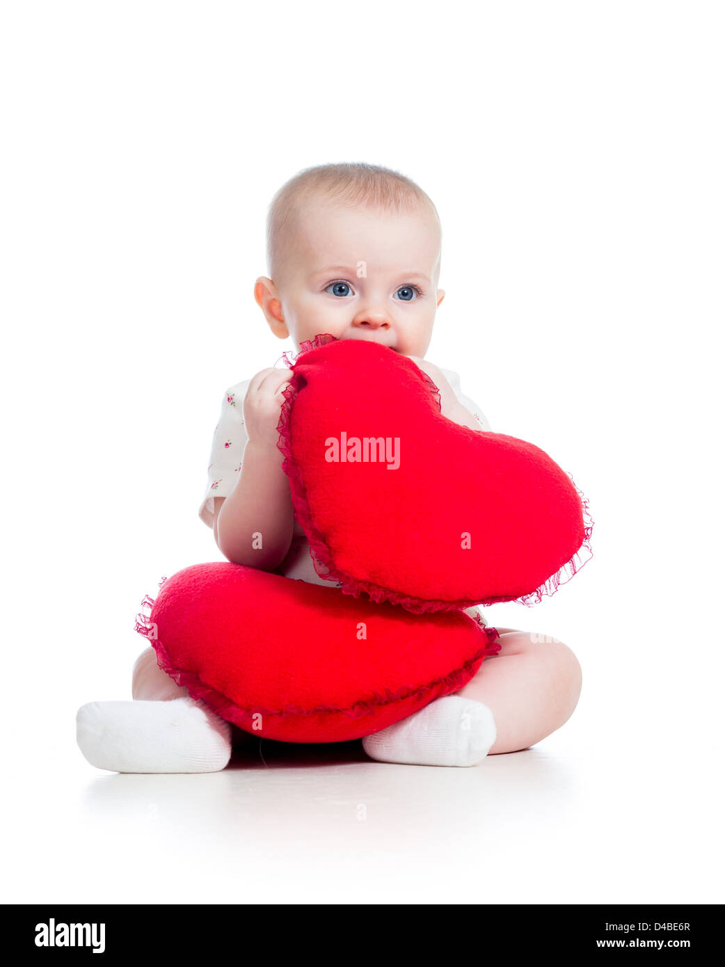 Babymädchen mit Kissen in Herzform Stockfoto