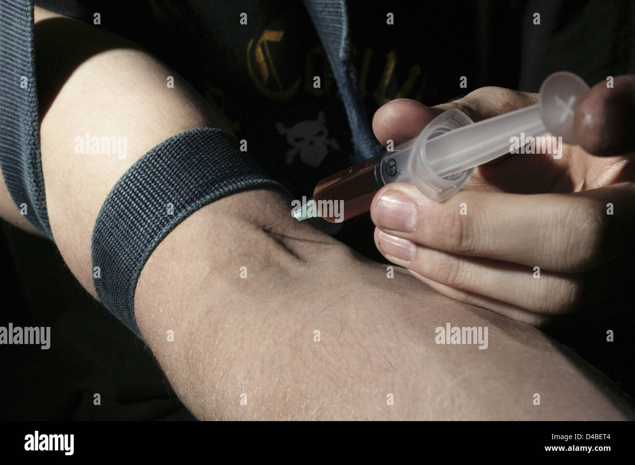 Ein Heroin Benutzer spritzt Heroin in Arm Benutzer verwendet Mund straffen Druckverband (in diesem Fall Gürtel) um Arm Heroin (Diacetyl Stockfoto