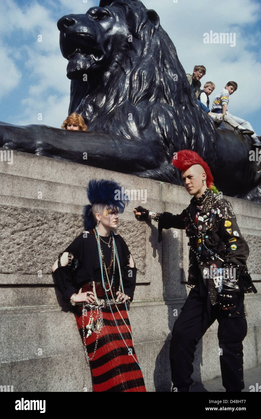 Ein paar Punk Rocker mit farbigen mohican Haar erregen die Aufmerksamkeit der Touristen am Trafalgar Square, London. Ca. 80er Stockfoto