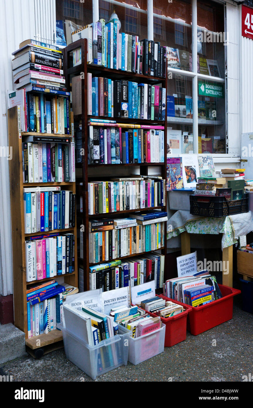 Bücher gestapelt auf Regalen und in den Feldern außerhalb ein Antiquariat. Stockfoto