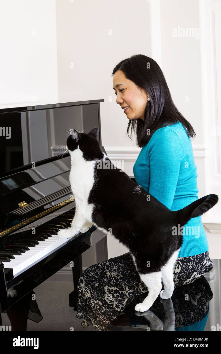 Vertikale Foto Reife Frau an ihrer Seite mit Familienkatze Klavier spielen Stockfoto