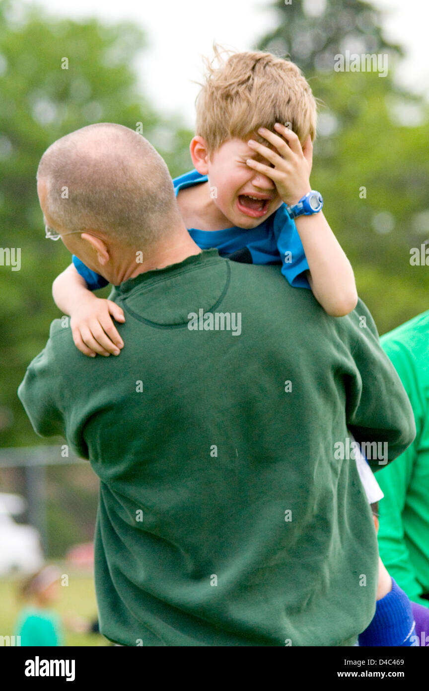 Weinende junge Fußballspieler dahingerafft Feld von Vater nach ein Fußball-Verletzungen Sport. St Paul Minnesota MN USA Stockfoto