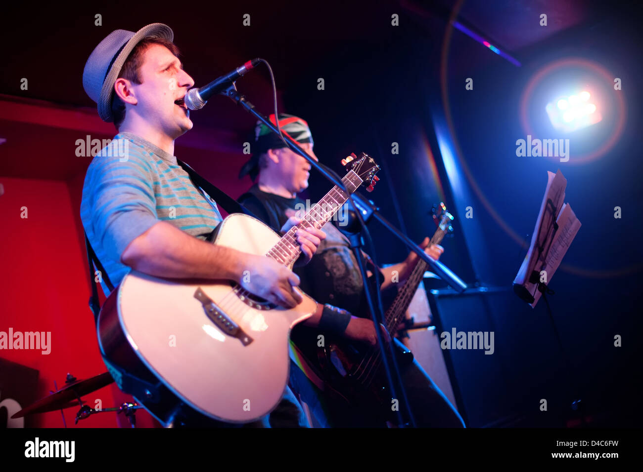 Musiker spielt eine Gitarre auf einem dunklen Hintergrund Stockfoto