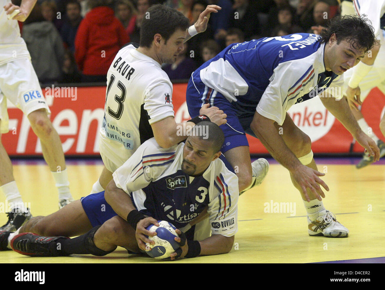 Markus Baur von Deutschland (L) und Jerome Fernandez France (R) Wäschetrockner über Frankreichs Didier Dinart (C) während der zweiten Phase-Partie Deutschland gegen Frankreich bei der EHF Euro 2008 in Trondheim, Norwegen, 23. Januar 2008. Frankreich gewann das Spiel 26-23. Foto: JENS WOLF Stockfoto