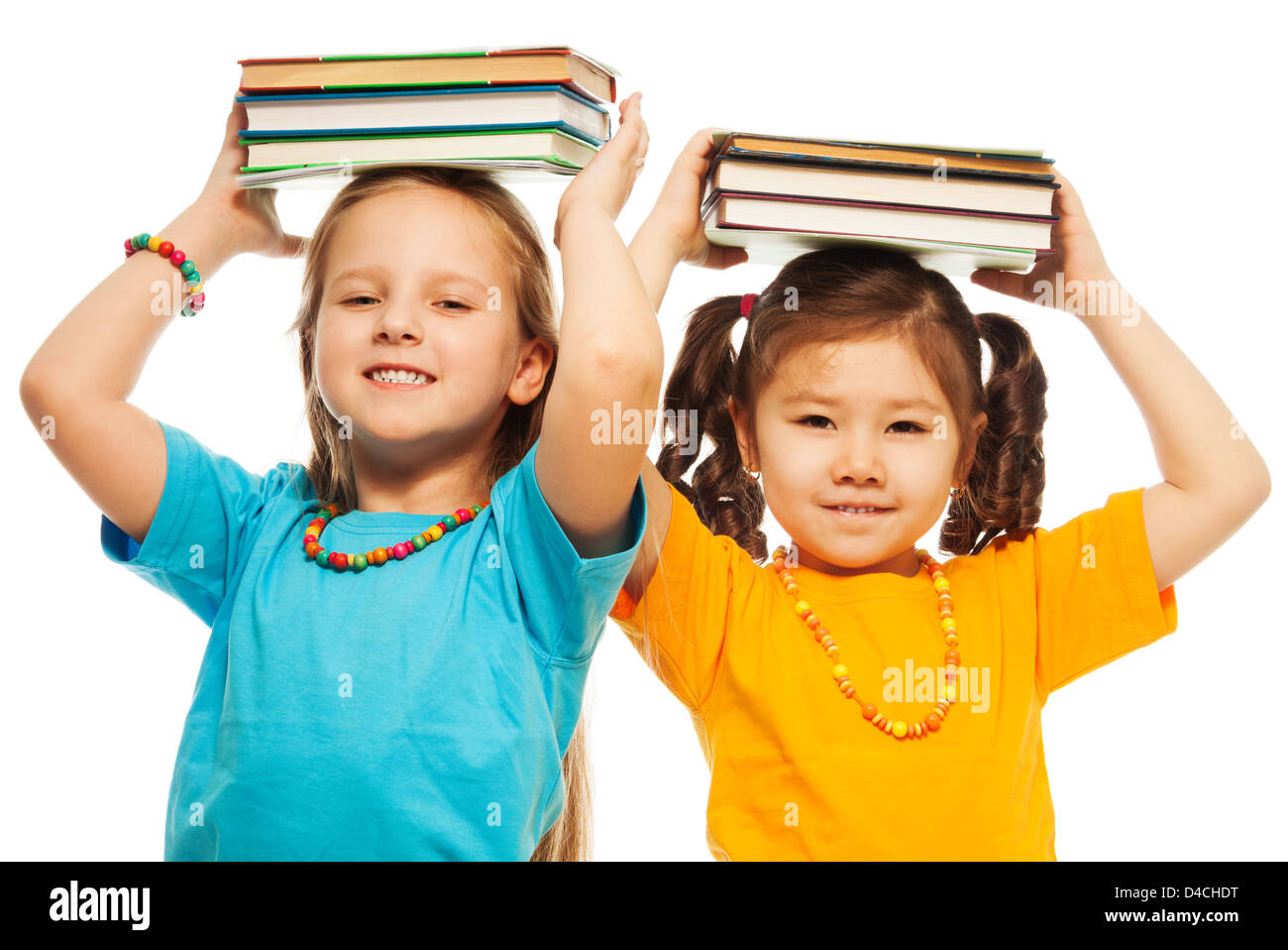 Zwei glückliche 6-7 Jahre alten Mädchen halten Stapel Bücher auf ihre Hand und lächelnd stand isoliert auf weiss Stockfoto