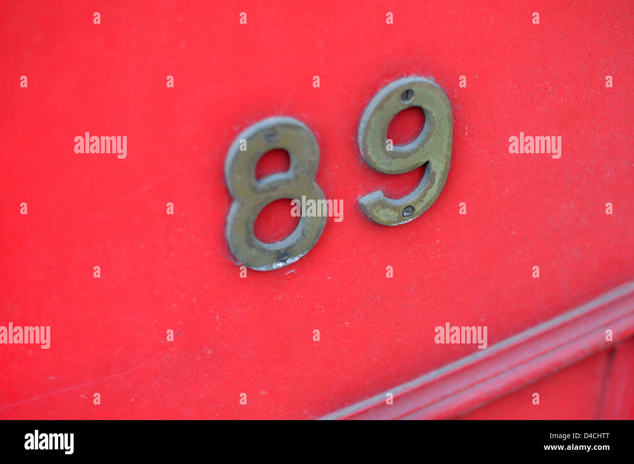Die Nummer 89 auf eine rote Haustür. Stockfoto