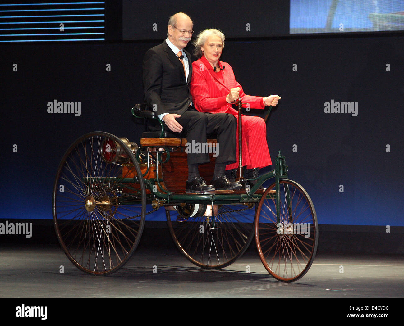 Dieter Zetsche (L), CEO der Daimler SE und Ur-Ur-Enkelin von Bertha Benz, Jutta Benz fahren eine Nachbildung des "Benz Patent Motorwagen III" aus dem 1888 an den Pressetag der 78. International Motor Show Genf, Schweiz, 4. März 2008. Rund 260 Aussteller aus 30 Nationen präsentieren auf 77.550 Quadratmetern ihre neuesten Entwicklungen bei der 78. International Motor Show Ge Stockfoto