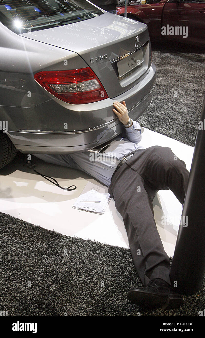 Datei - ein Mann inspiziert die Fußbodenheizung ein Mercedes C 280 auf der Genfer Motor Show, Schweiz, 7. März 2007. Foto von Uli Deck gewann den zweiten Preis in der Kategorie "Wirtschaft". Die Deutsche Presse-Agentur GmbH hat zum siebten Mal die "DPA-Foto des Jahres" Preis in Hamburg verliehen. Foto: ULI DECK Stockfoto