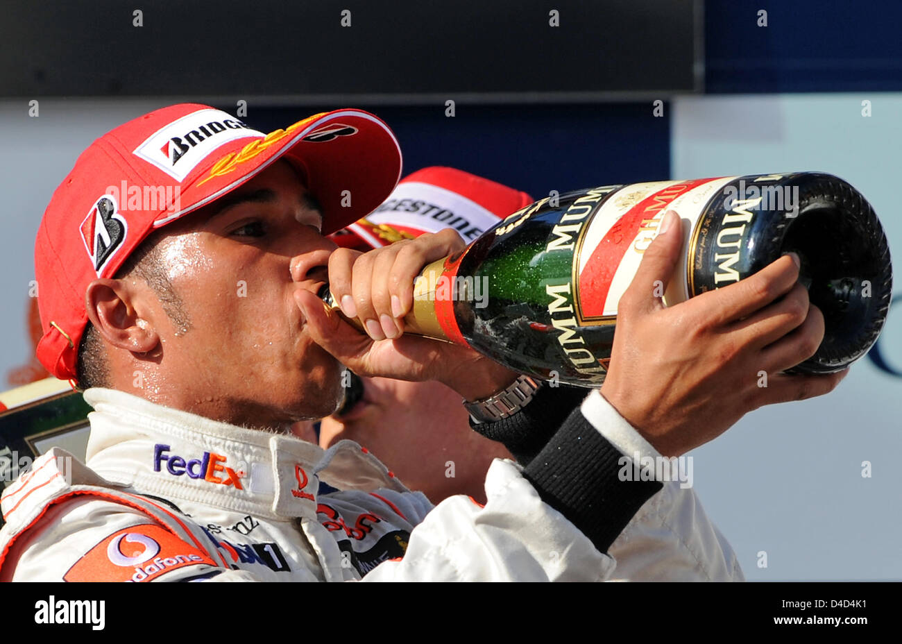 Britischer Formel-1-Fahrer Lewis Hamilton trinkt Champagner auf dem Podium nach dem Gewinn der Formel 1 Australian Grand Prix im Albert Park Circuit in Melbourne, Australien, 16. März 2008. Heidfeld wurde zweite und Rosberg Dritter. Foto: GERO BRELOER Stockfoto