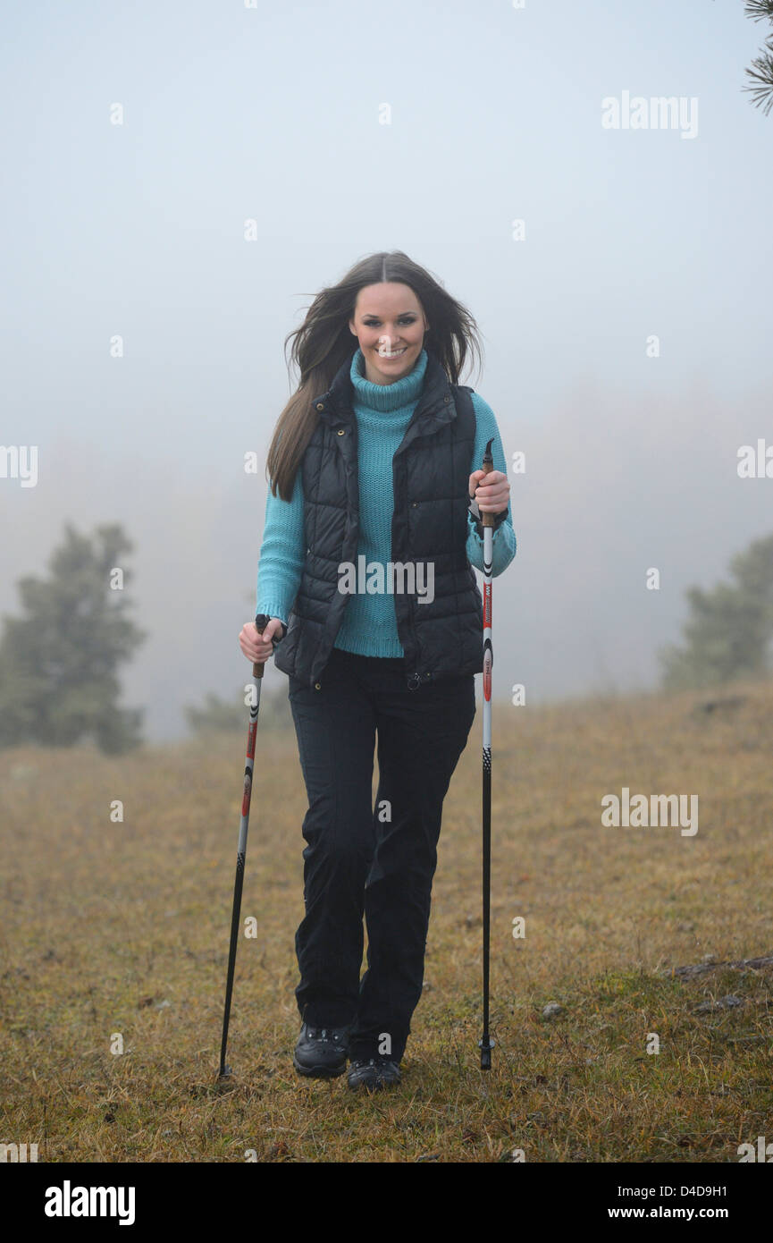 Brünette junge Frau, die Nordic-walking Stockfoto