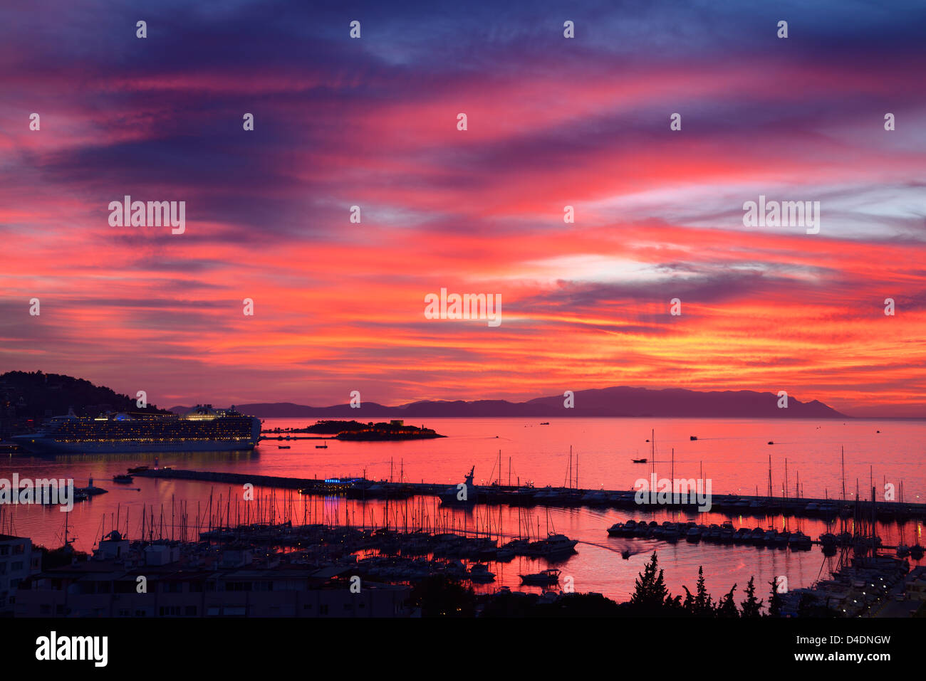 Roter Himmel Sonnenuntergang bei Kusadasi Türkei Hafen mit Schiff und guvercin adasi Schloss an der Ägäis mit Bergen von Samos Stockfoto