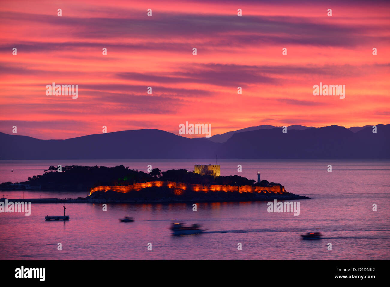 Roter Himmel Sonnenuntergang bei Kusadasi Türkei Hafen mit beleuchteten guvercin adasi Insel Burg auf die Ägäis mit Bergen von Samos, Griechenland Stockfoto