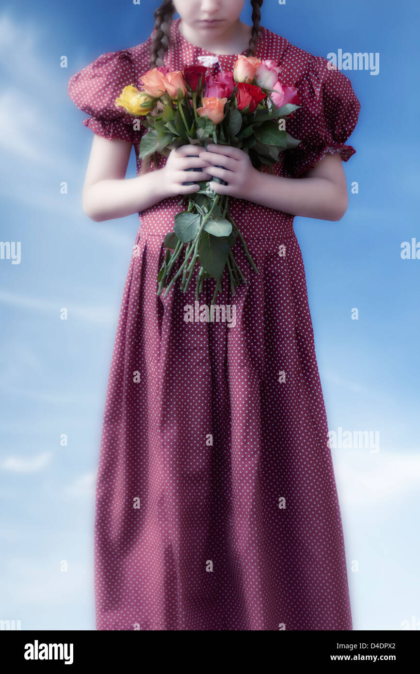 ein Mädchen in einem roten Kleid mit einem Blumenstrauß Stockfoto