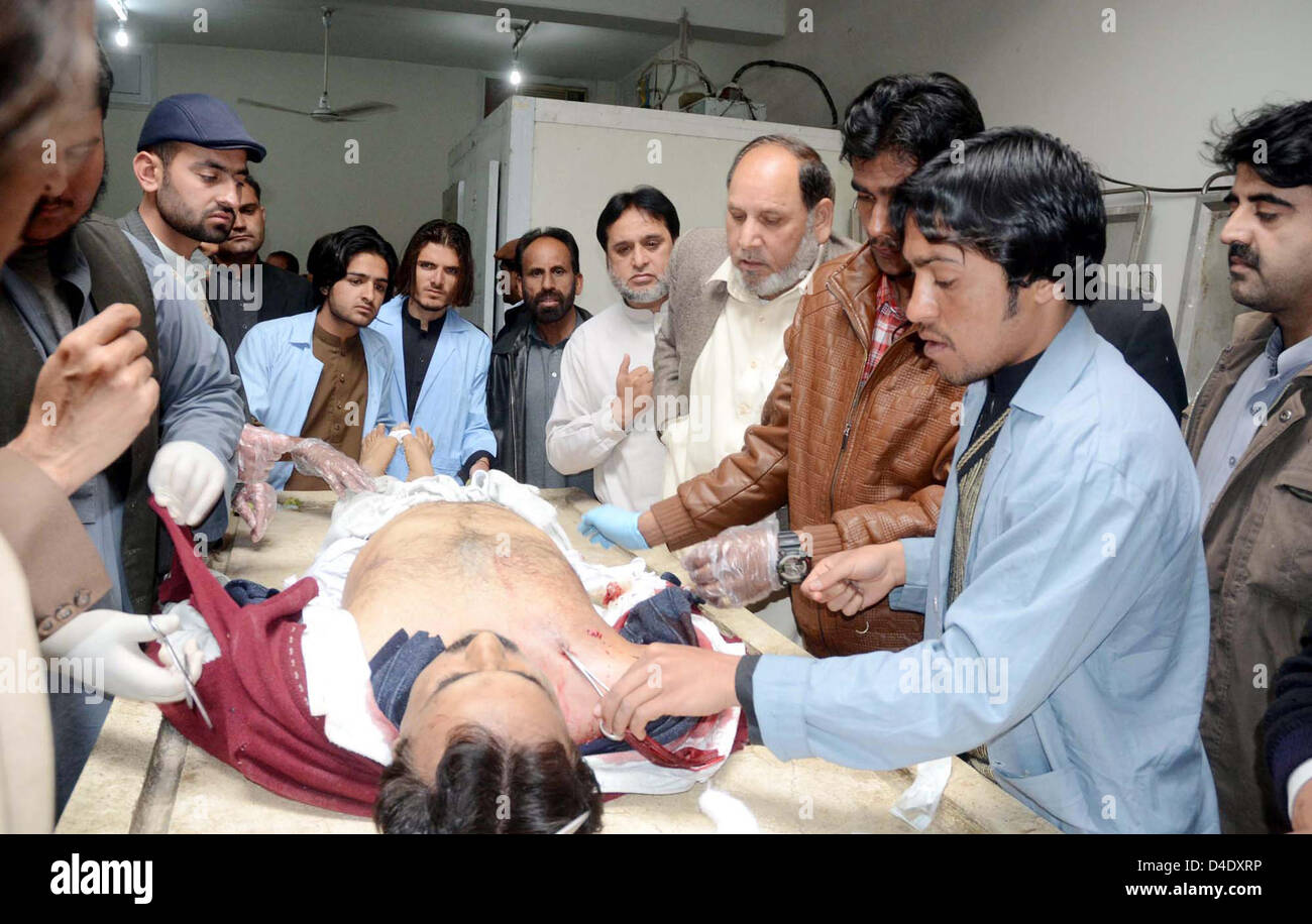 Menschen und paramedizinischer Personal versammeln sich in der Nähe einer der Wahl Kommissar von Quetta, Ziaullah Qasmi, die durch nicht identifizierte Person, in örtlichen Krankenhaus in Quetta auf Dienstag, 12. März 2013 niedergeschossen wurde. Stockfoto