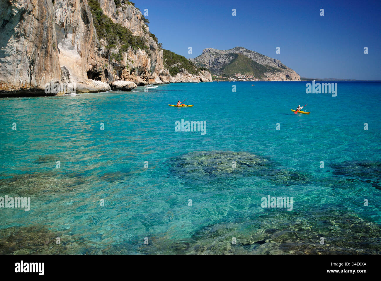 Touristen mit Kajaks die transparente Gewässer des Mittelmeeres entlang der Küste von Cala Gonone, Golf von Orosei, Sardinien Segeln Stockfoto