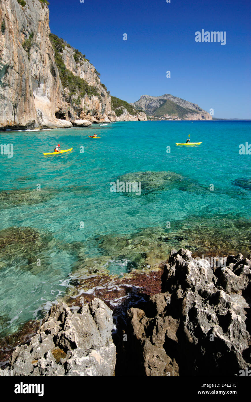 Touristen mit Kajaks die transparente Gewässer des Mittelmeeres entlang der Küste von Cala Gonone, Golf von Orosei, Sardinien Segeln Stockfoto