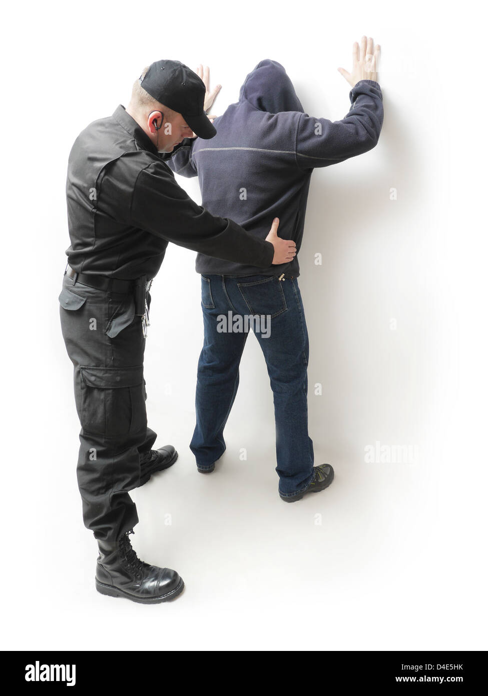Mann wird von einem Polizisten in schwarzer Uniform gesucht Stockfoto