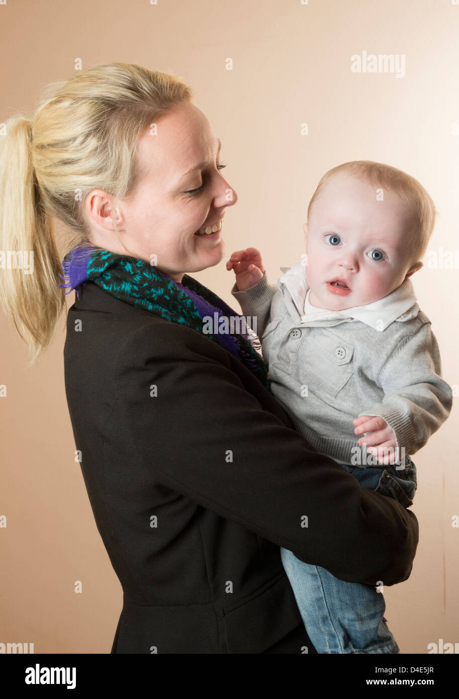 Junge Mutter hält ihr Baby junge 6 Monate alt Stockfoto