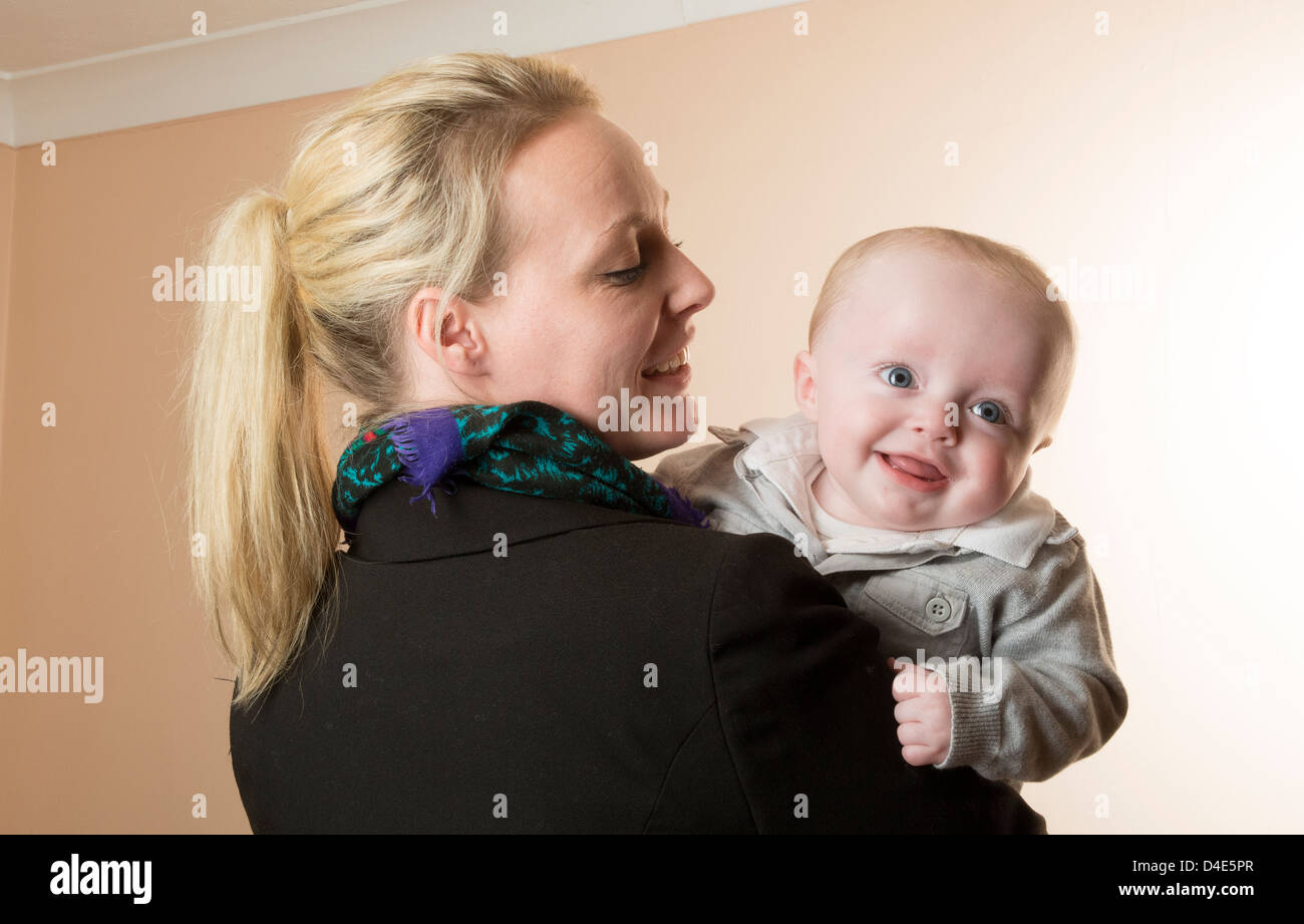 Junge Mutter hält ihr Baby junge 6 Monate alt Stockfoto