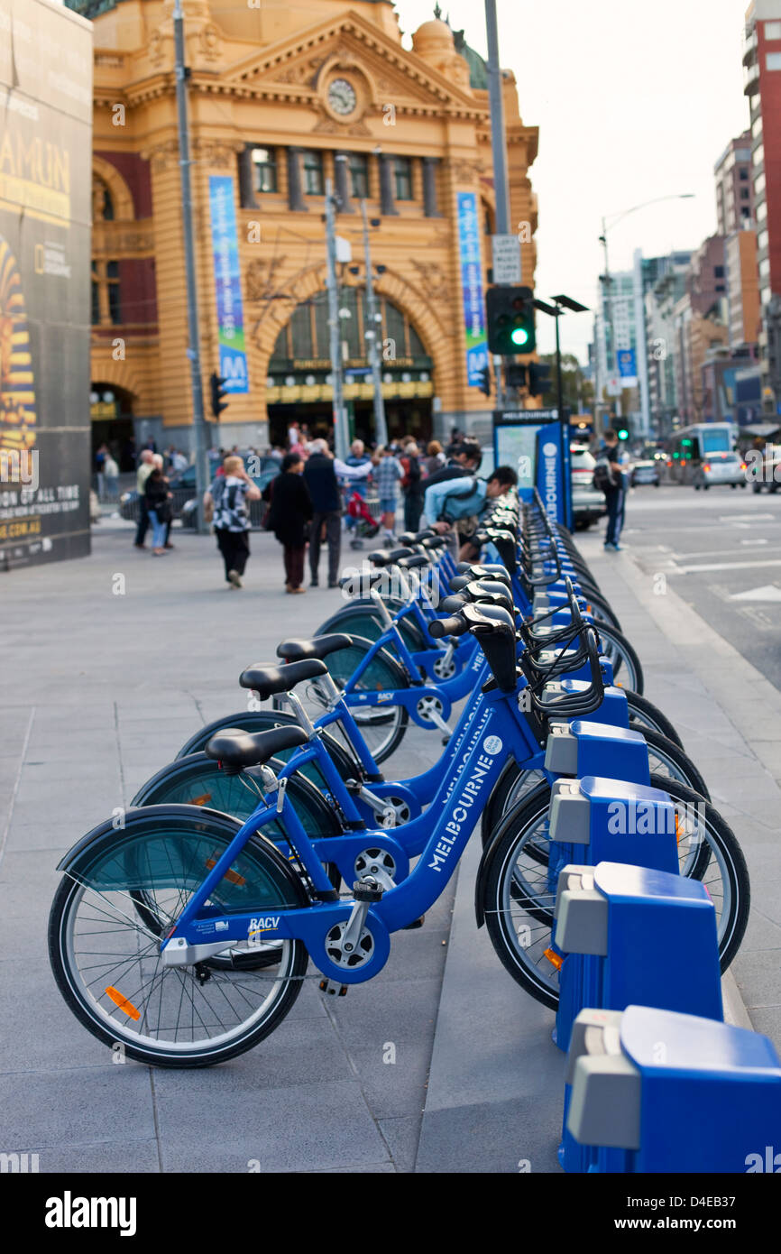Fahrrad Fahrräder Anteil am Federation Square mit Flinders Street Station im Hintergrund. Melbourne, Victoria, Australien Stockfoto