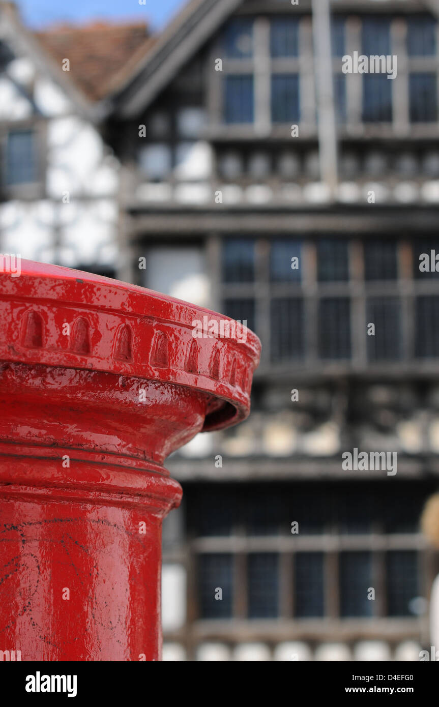 Eine traditionelle hellen roten englischen Briefkasten mit einem Rücken-Tropfen eine authentische Tudor Gebäude in London. Stockfoto