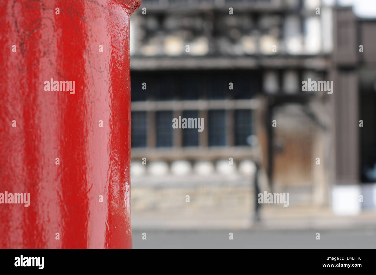 Eine traditionelle hellen roten englischen Briefkasten mit einem Rücken-Tropfen eine authentische Tudor Gebäude in London. Stockfoto