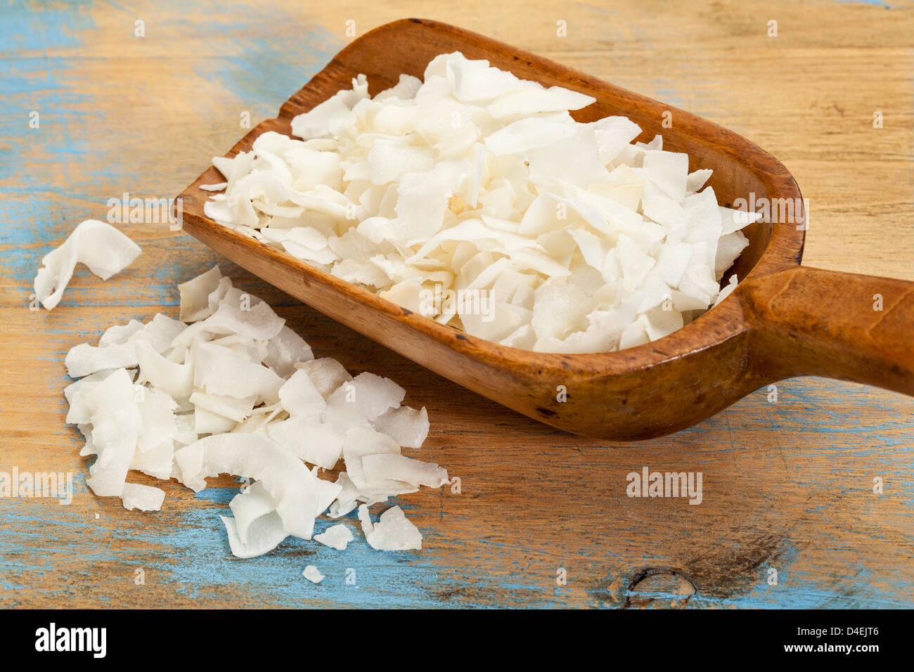 Flocken von Kokosraspeln auf einer rustikalen hölzernen Schaufel Stockfoto