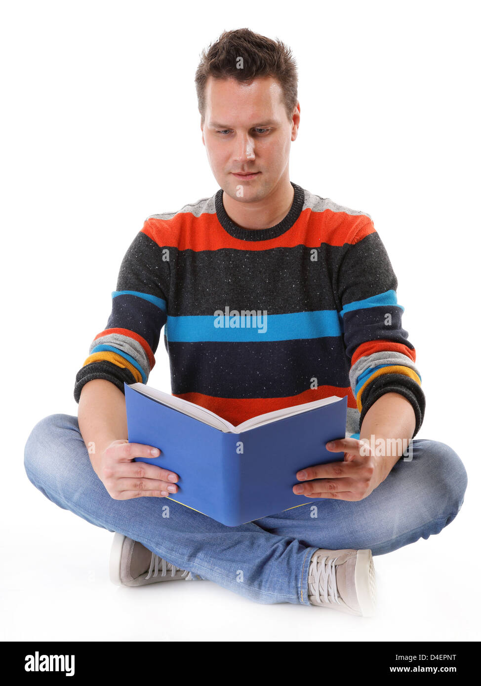 junger Mann, ein Buch zu lesen oder studieren auf dem Boden isoliert auf weiss Stockfoto
