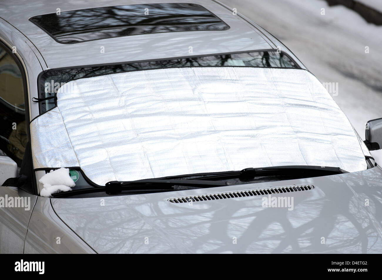 Ein Frostschutzmittel plane wird an der Windschutzscheibe eines Autos  Stockfotografie - Alamy