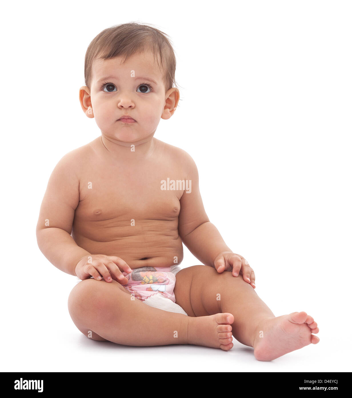 Lustige ernsthaftes kleines Baby sitzt auf dem Boden. Isoliert auf weißem Hintergrund. Stockfoto