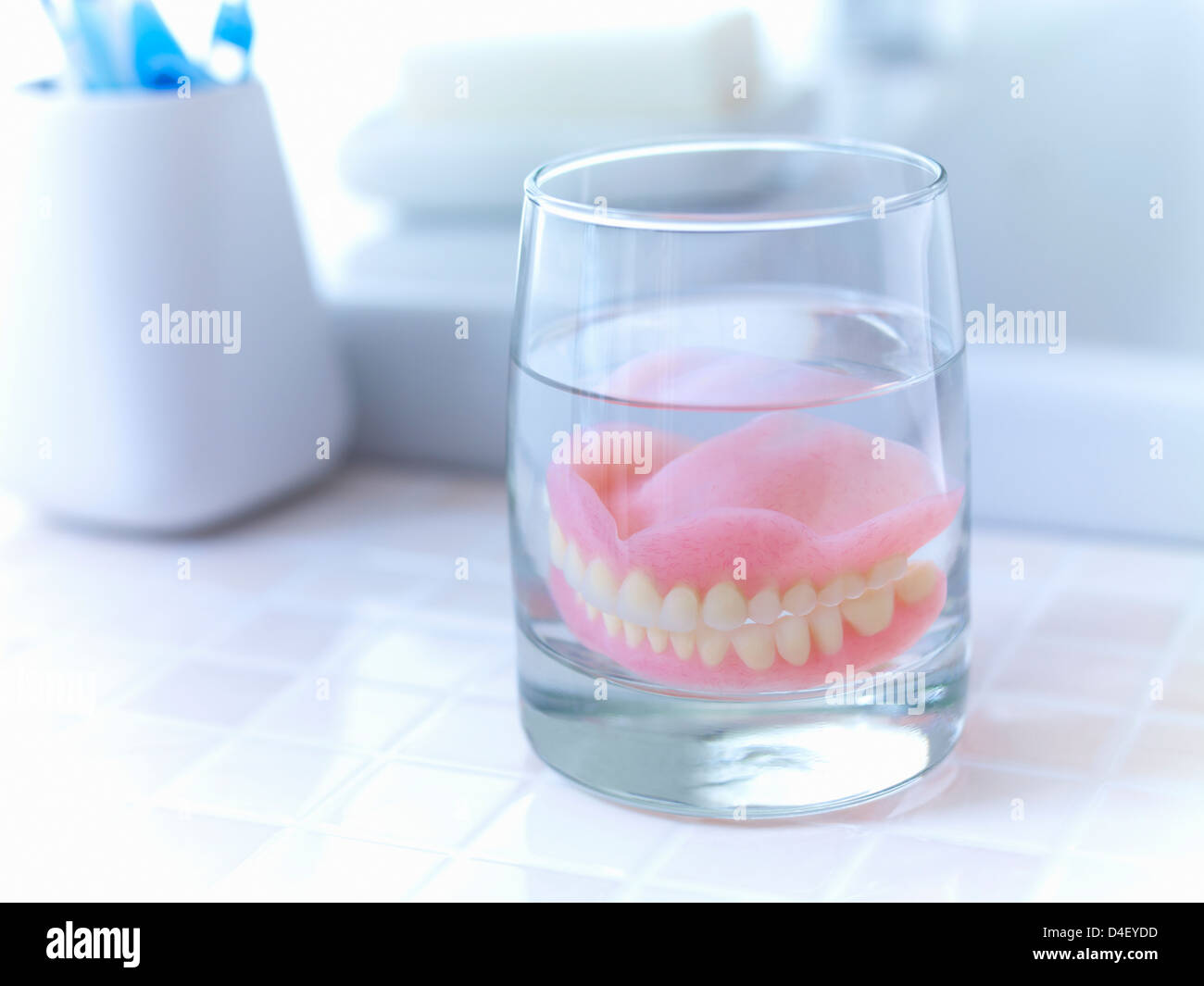 Nahaufnahme von Zahnersatz in Glas Wasser einweichen Stockfoto