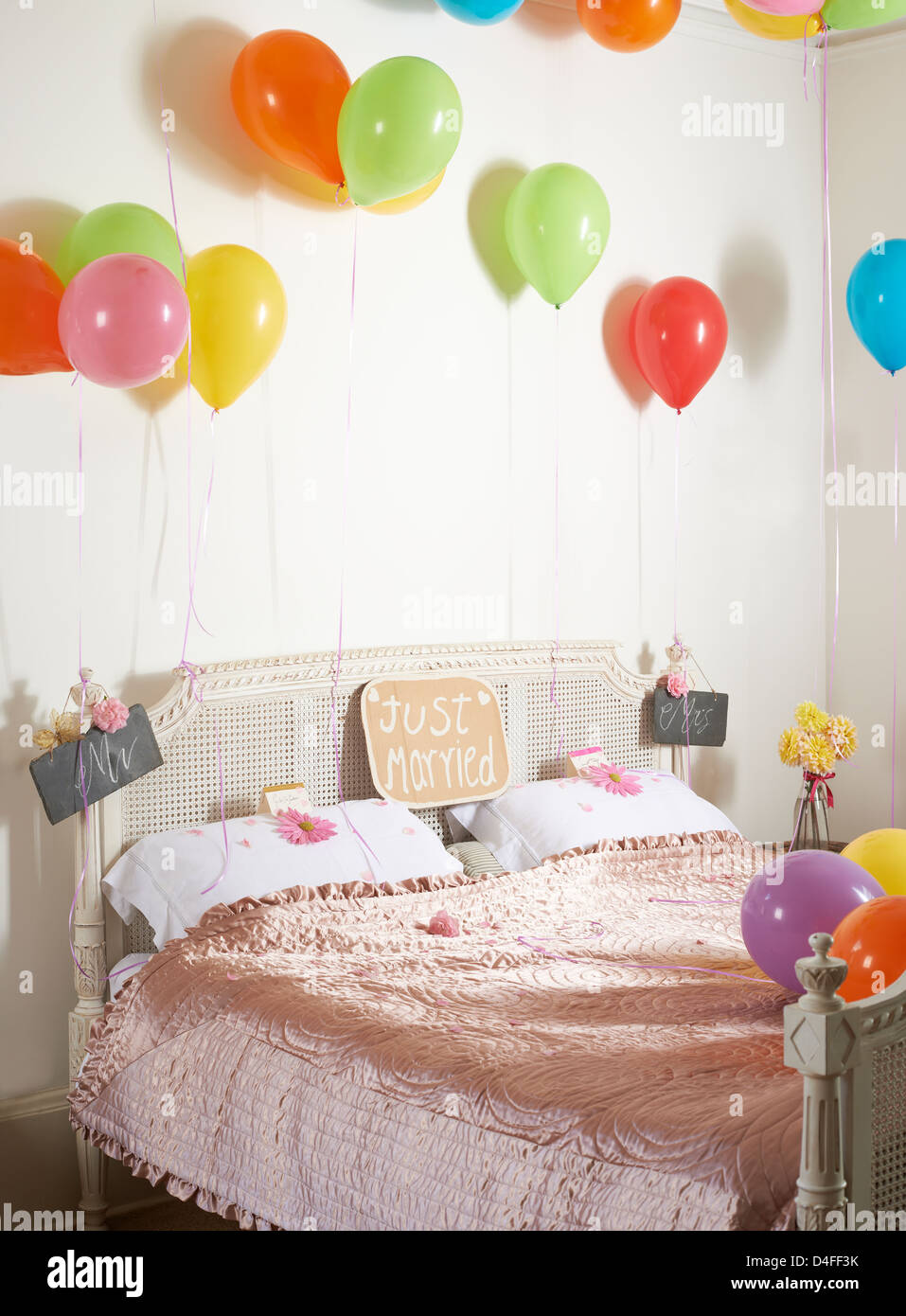 Bunte Luftballons über Ehebett Stockfoto