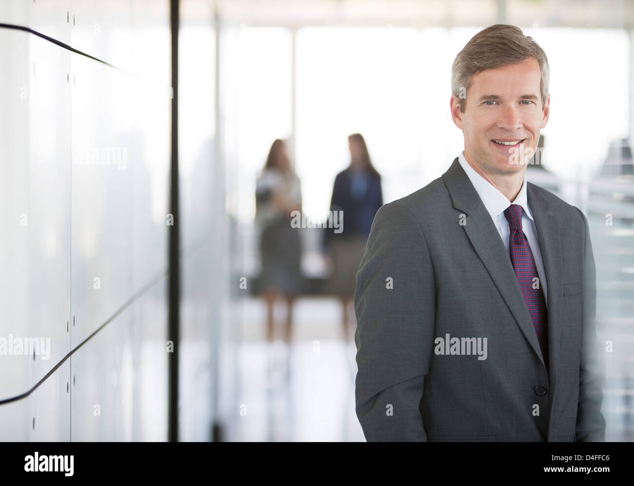 Geschäftsmann lächelnd in Büro Flur Stockfoto