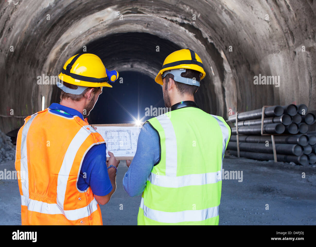 Arbeiter lesen Blaupausen in tunnel Stockfoto