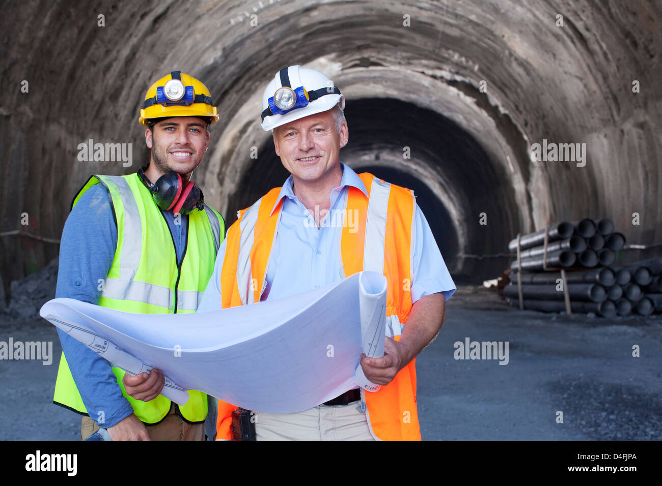Arbeiter lesen Blaupausen in tunnel Stockfoto