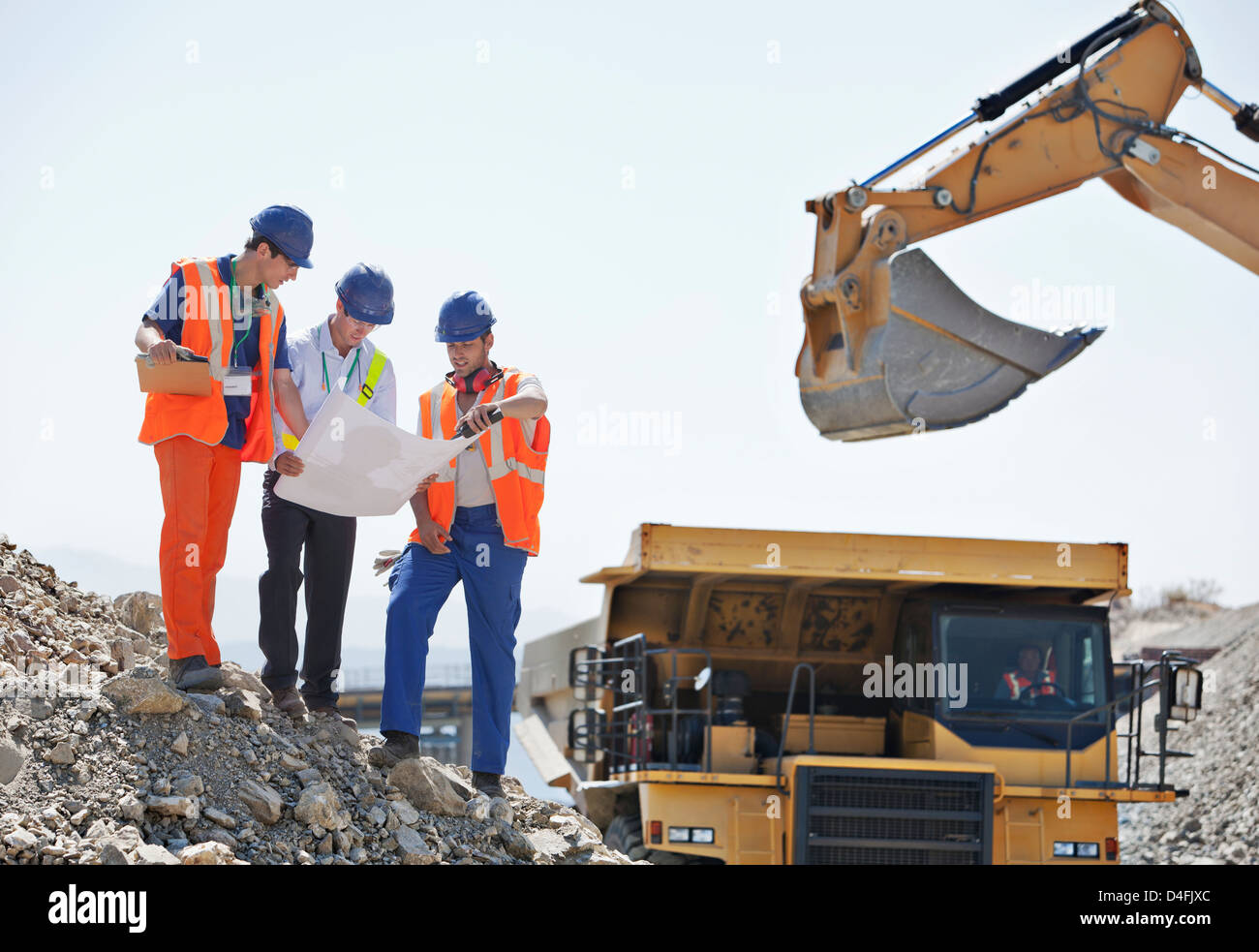 Arbeitnehmer und Unternehmer lesen Baupläne im Steinbruch Stockfoto