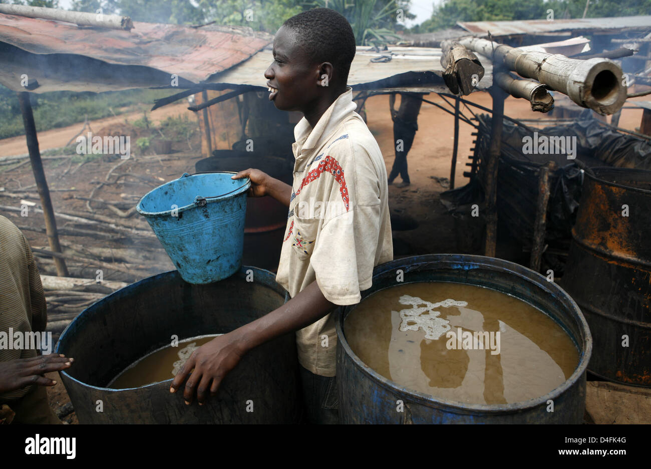 Ein ghanaischer destilliert reinen Alkohol aus Zuckerrohr in Asesewa, Ghana, 18. Juni 2008. Foto: Jens Ressing Stockfoto