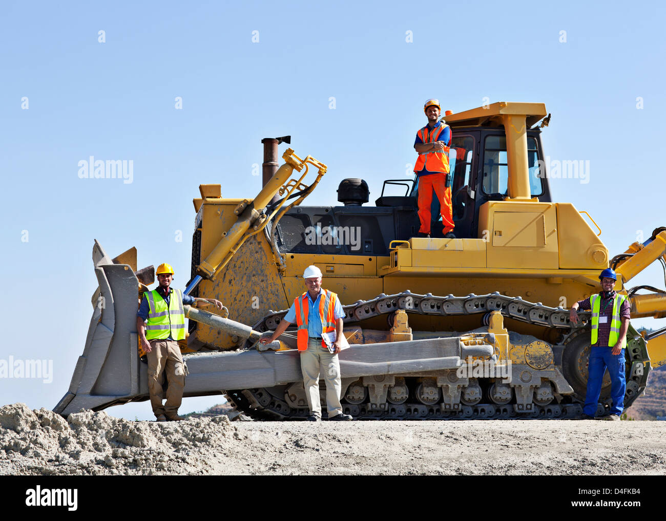 Arbeitnehmer auf Bulldozer lächelnd im Steinbruch Stockfoto
