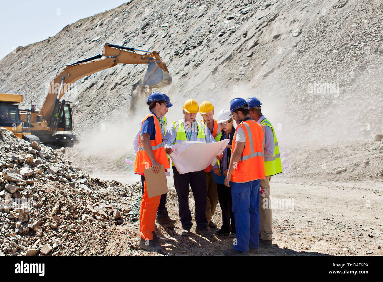 Geschäftsleute und Arbeiter im Steinbruch im Gespräch Stockfoto