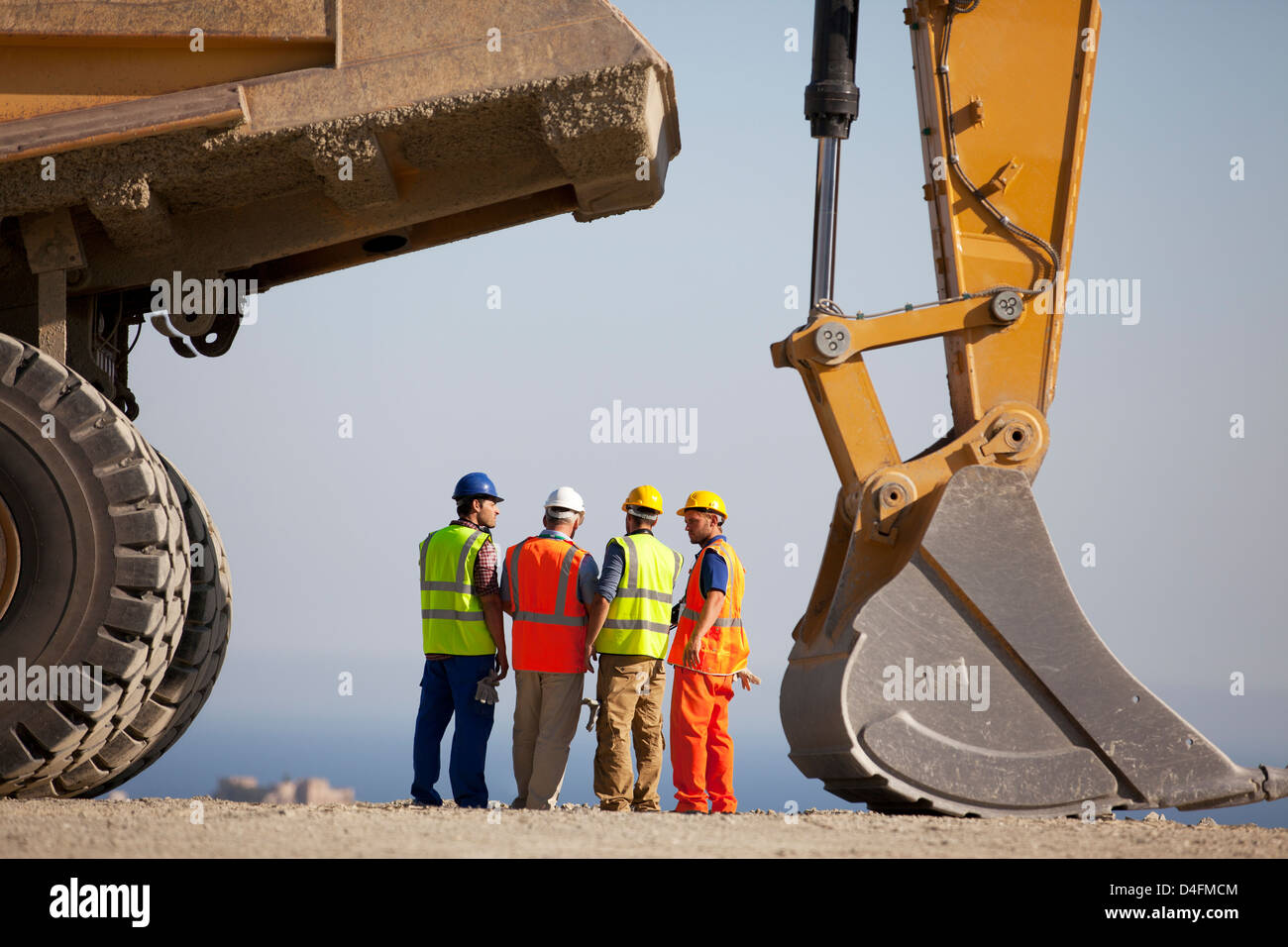 Arbeitnehmer, die reden von Maschinen im Steinbruch Stockfoto